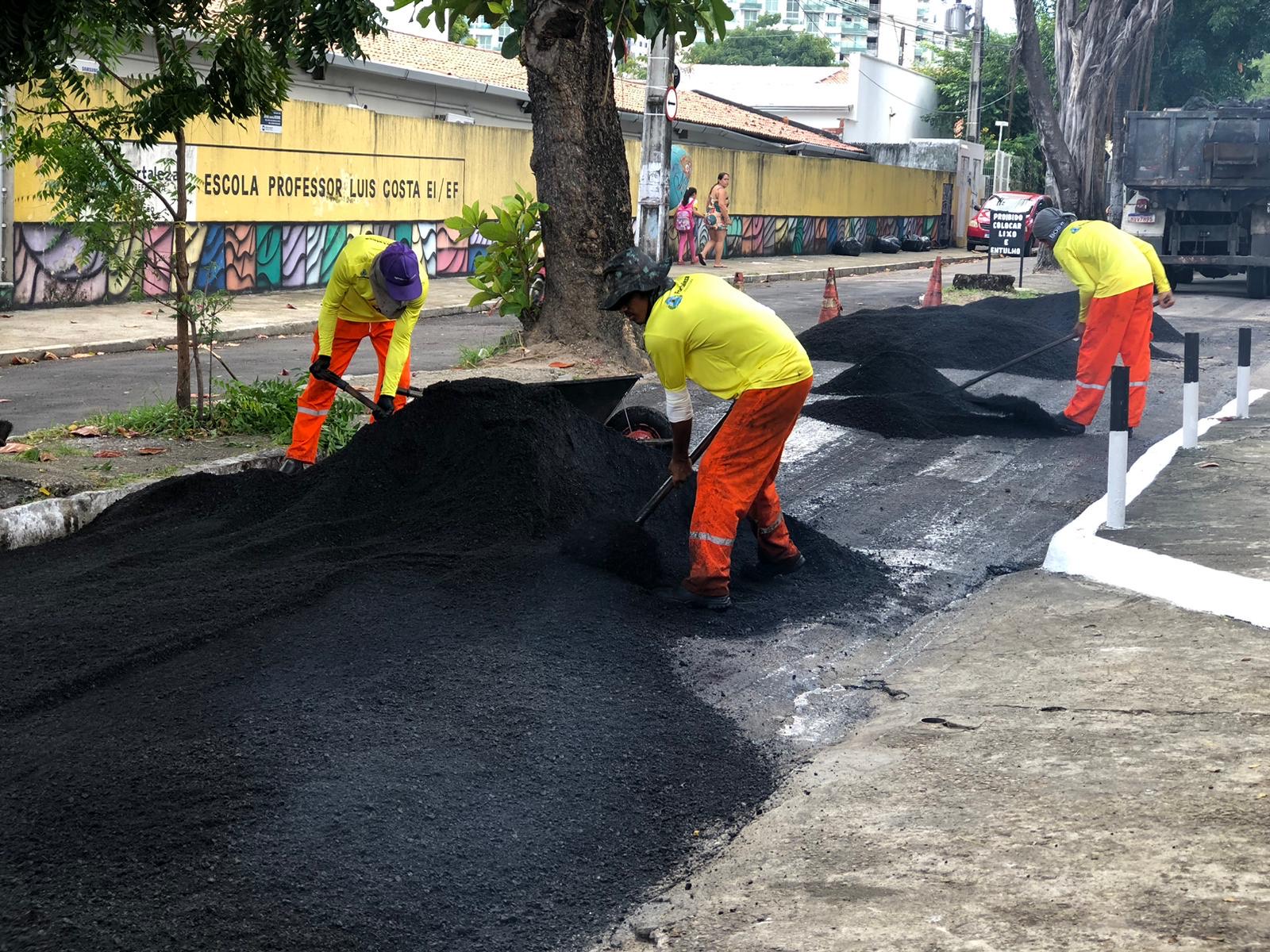 homens asfaltando uma via